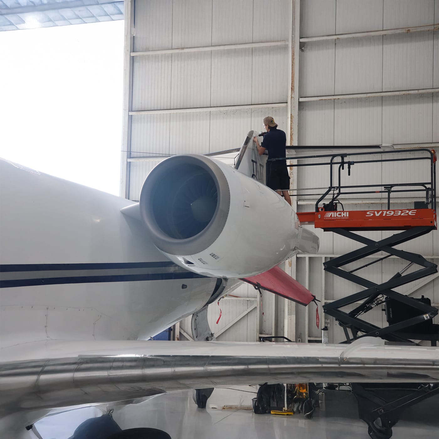 Learjet aircraft being serviced by technician front