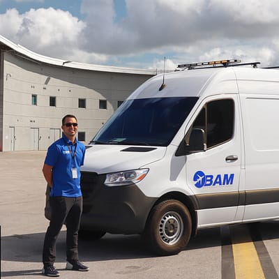 Employee in front of company van at airport